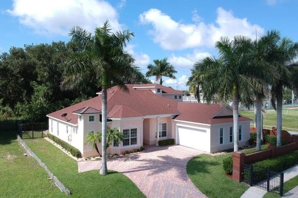 aerial front view of a home surrounded by palm trees