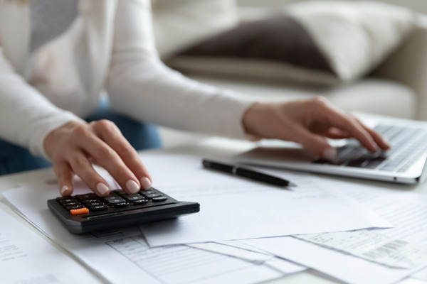 woman's hands using calculator with accounting paperwork