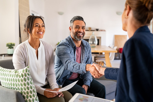 woman and man on couch shaking hands with a woman in a blaze