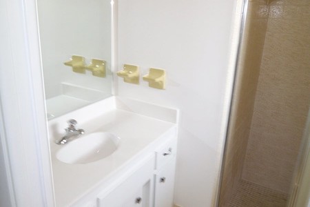 Before - Harvest gold vinyl flooring, shower tile and toilet were past their expiration date